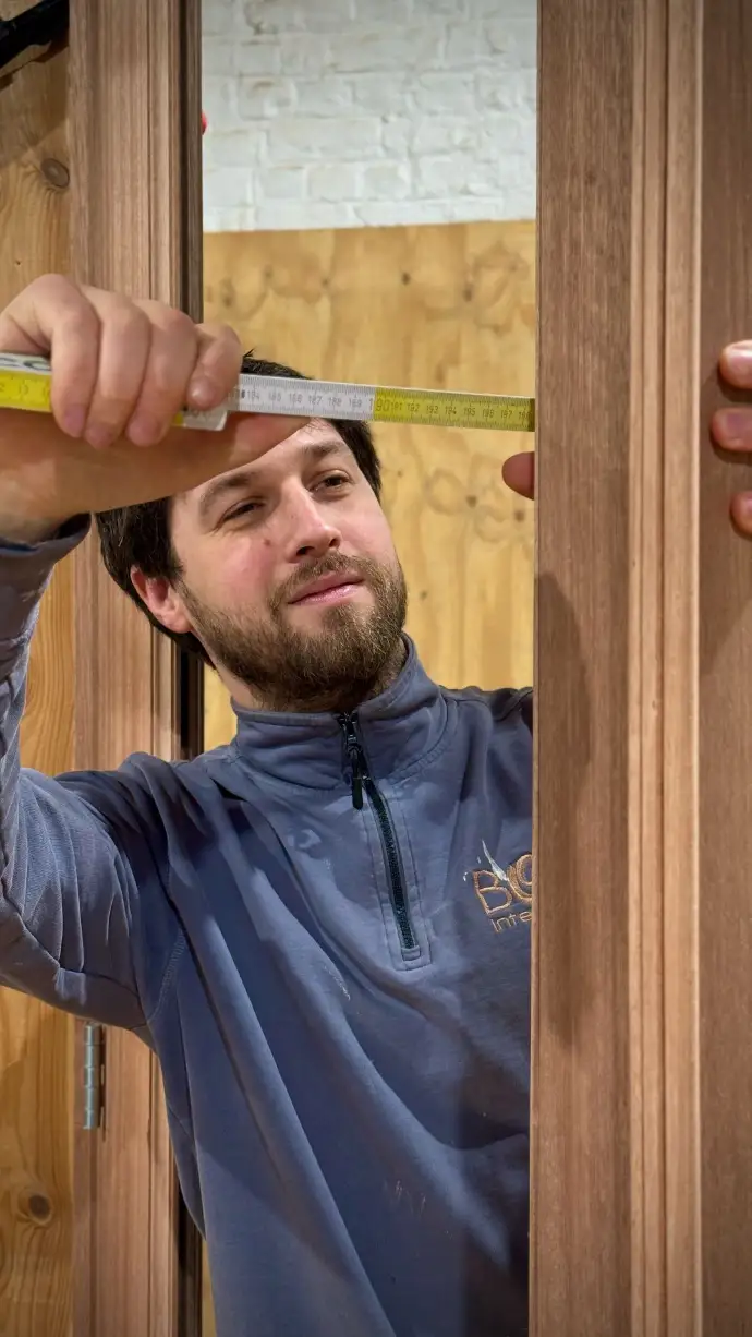 Loïc Penna, menuisier, qui prend vérifie des mesures d'une porte en bois massif