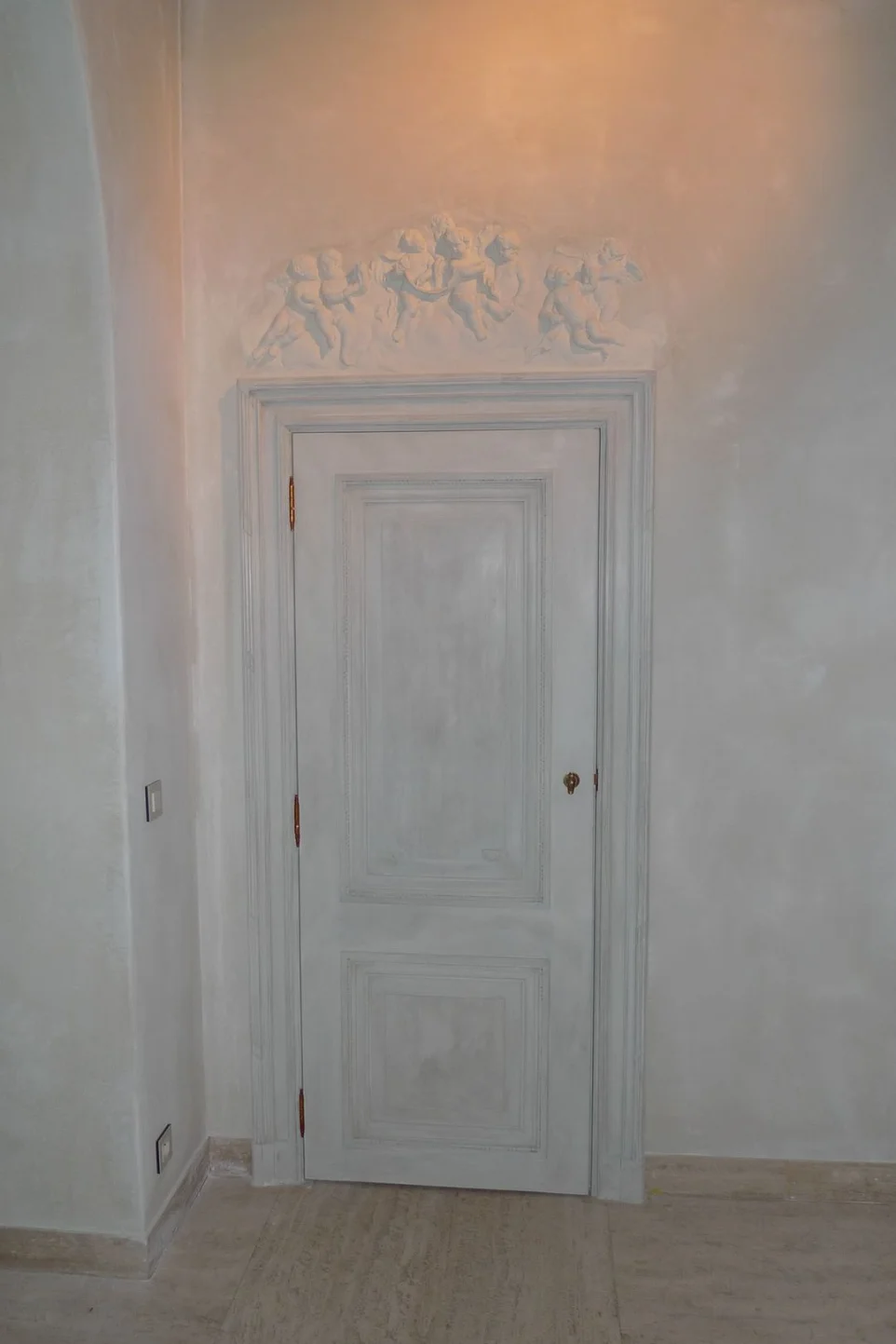 Porte mouluré et sculpté avec des anges sculptés en surplomb