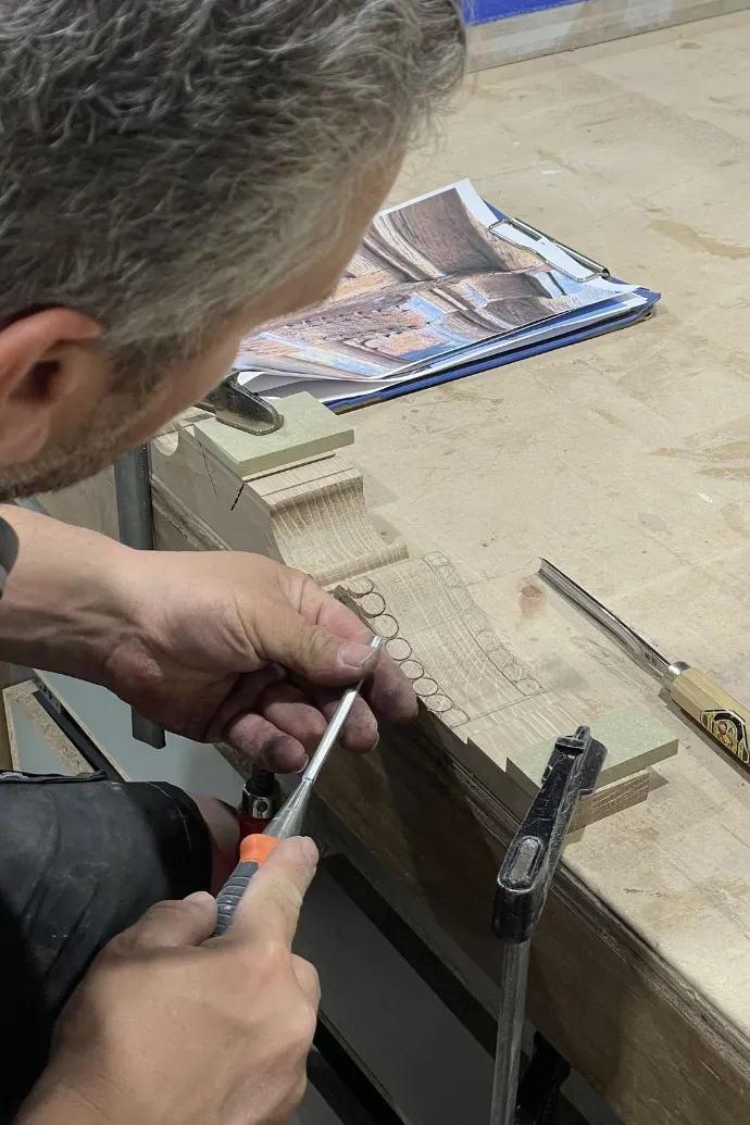 Menuisier sculptant une porte en bois