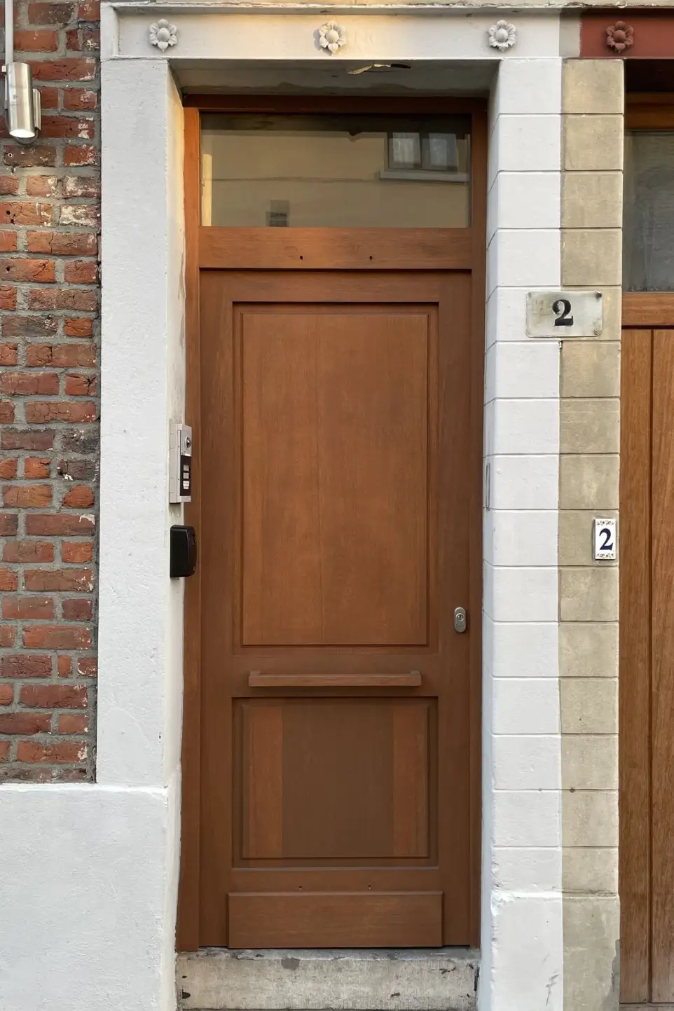 Porte d'entrée en méranti massif huilé avec imposte et poignée bois