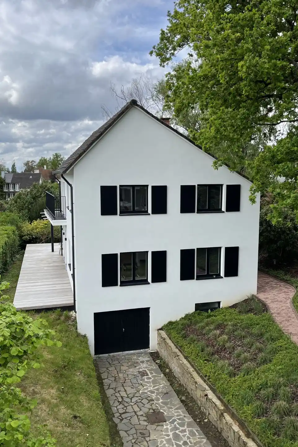 Villa moderne avec porte de garage noire double battant et volets décoratifs noirs