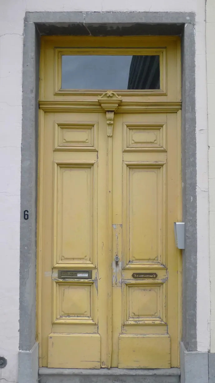Porte d'entrée sculptée d'une maison de maître bruxelloise