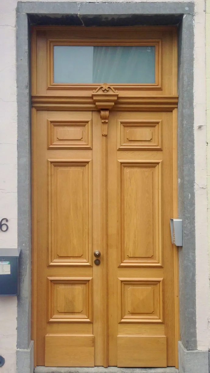 Porte d'entrée sculptée d'une maison de maître bruxelloise