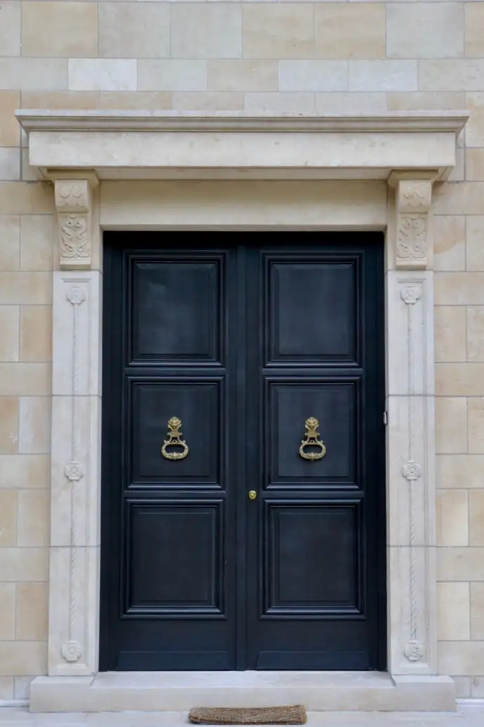 Double porte d entrée noire avec heurtoir et encadrement en pierre sculptée